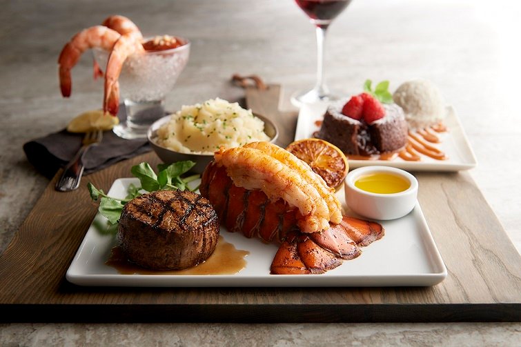 A plate of food with steak, lobster, and mashed potatoes.